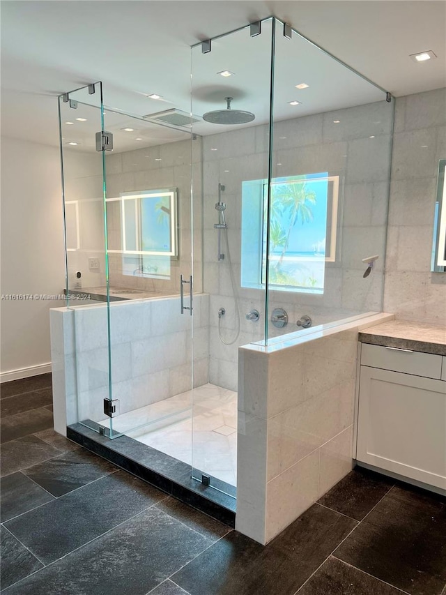 bathroom with a healthy amount of sunlight, tile patterned floors, a shower with door, and vanity