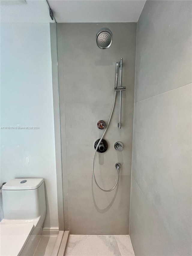 bathroom featuring toilet and a tile shower