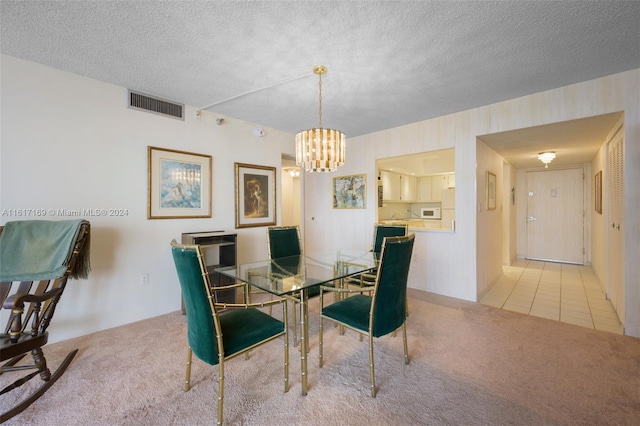 dining space with light carpet, a chandelier, and a textured ceiling