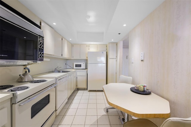 kitchen with light tile patterned floors, white appliances, a raised ceiling, and sink