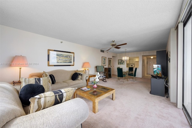 carpeted living room featuring ceiling fan and a textured ceiling