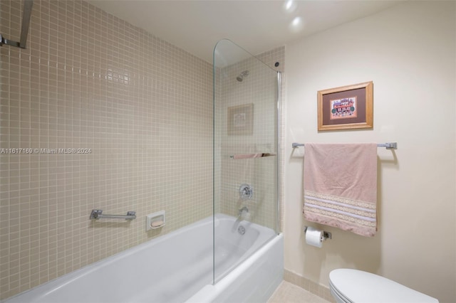 bathroom with tile patterned flooring, toilet, and tiled shower / bath