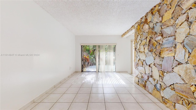 tiled spare room with a textured ceiling