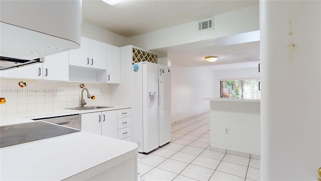 kitchen featuring extractor fan, sink, backsplash, white refrigerator with ice dispenser, and white cabinetry