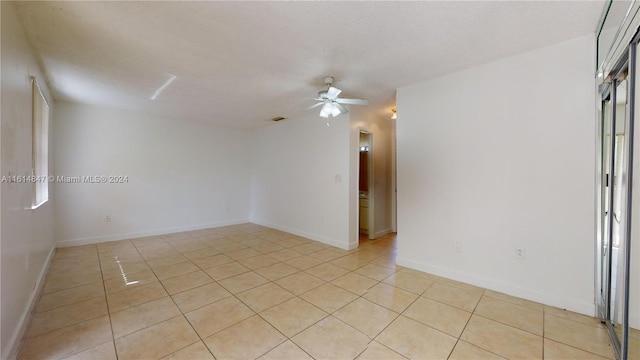 spare room featuring ceiling fan and light tile patterned floors