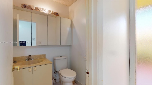 bathroom with vanity, a textured ceiling, and toilet