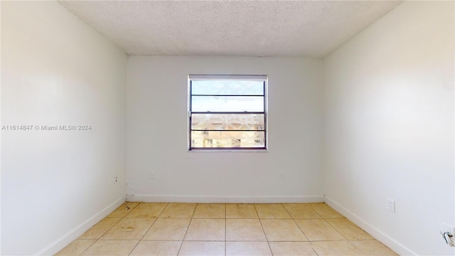 tiled spare room with a textured ceiling