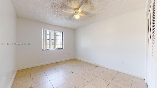 tiled spare room featuring ceiling fan and a textured ceiling