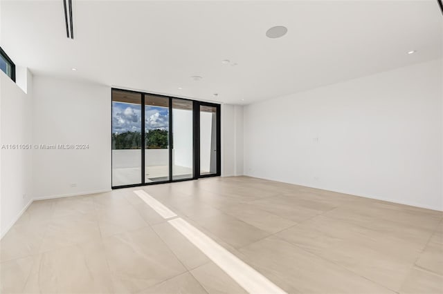 2832 Coconut Ave Unit 2832, Miami, FL 33133 - spare room with a wall of windows, baseboards, recessed lighting, and light tile patterned floors