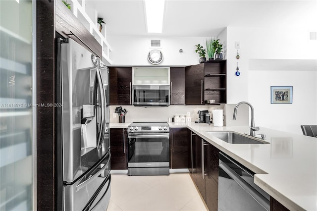 kitchen with light tile patterned flooring, stainless steel appliances, sink, and dark brown cabinets