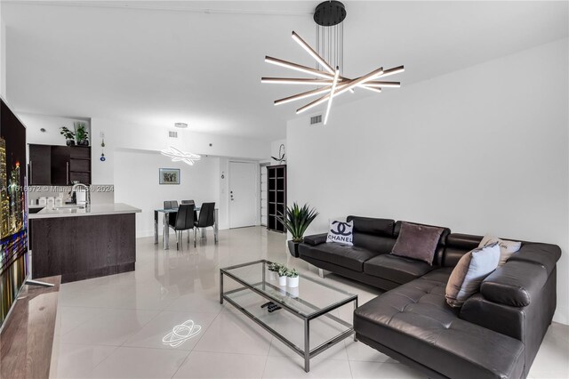 tiled living room with sink and a notable chandelier