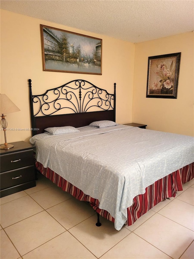 bedroom featuring a textured ceiling and tile patterned flooring