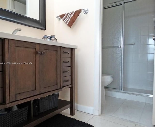 bathroom with vanity, walk in shower, tile patterned flooring, and toilet