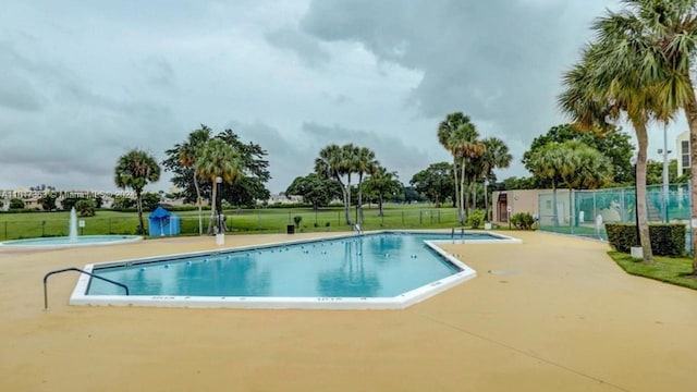 view of pool featuring a lawn and a patio area