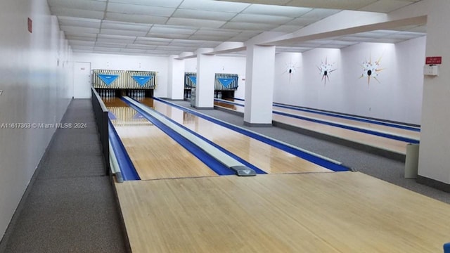 playroom with bowling and a drop ceiling