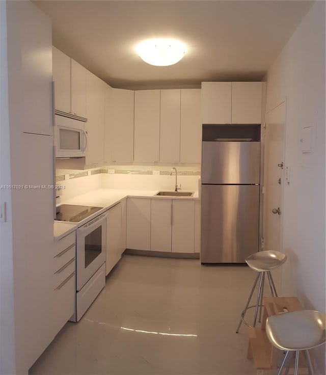 kitchen featuring white cabinets, sink, and white appliances