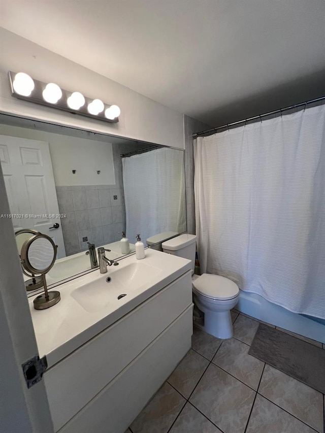 full bathroom with shower / bath combo with shower curtain, vanity, tile patterned flooring, and toilet