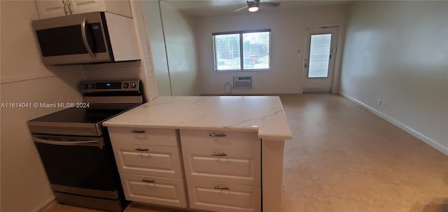 kitchen featuring white cabinets, light stone countertops, range with electric cooktop, and ceiling fan