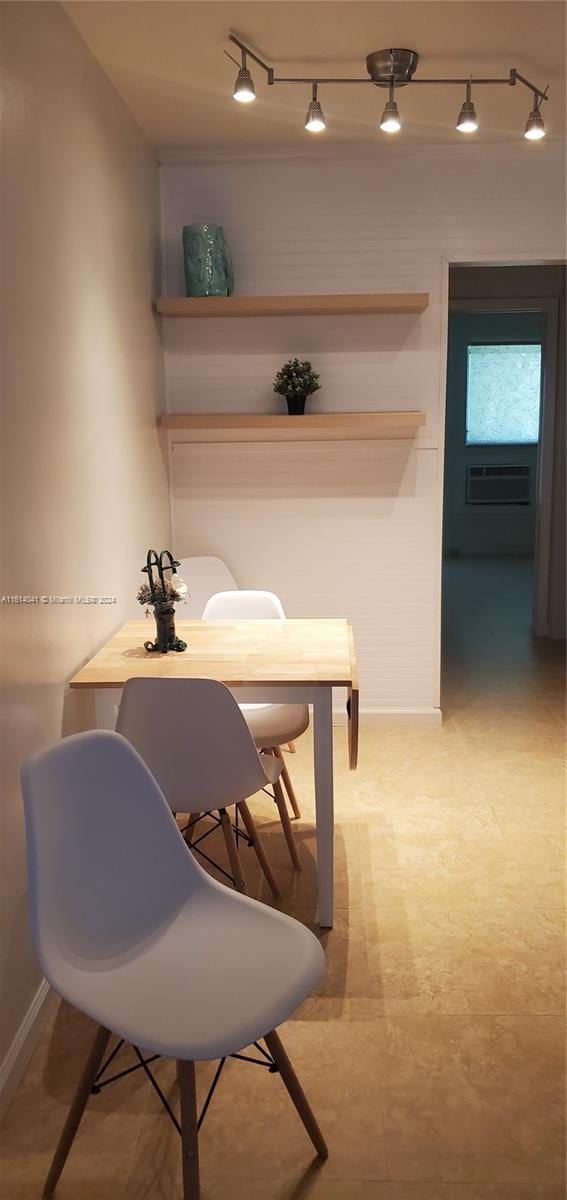 dining room featuring a wall mounted air conditioner, light tile patterned floors, and rail lighting