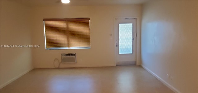 unfurnished room with concrete floors, a wall mounted air conditioner, and plenty of natural light