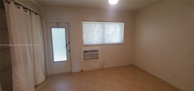 spare room with a wall mounted AC and a wealth of natural light