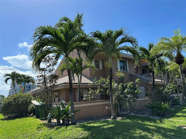 708 SE 3rd Ave Unit 201, Hallandale Beach, FL 33009 - rear view of house featuring stucco siding and a lawn