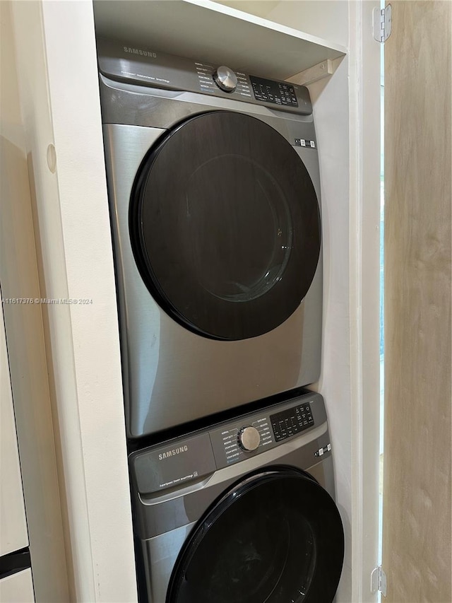 washroom featuring stacked washer and clothes dryer