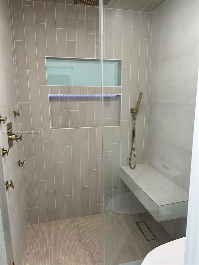 bathroom featuring toilet and a tile shower