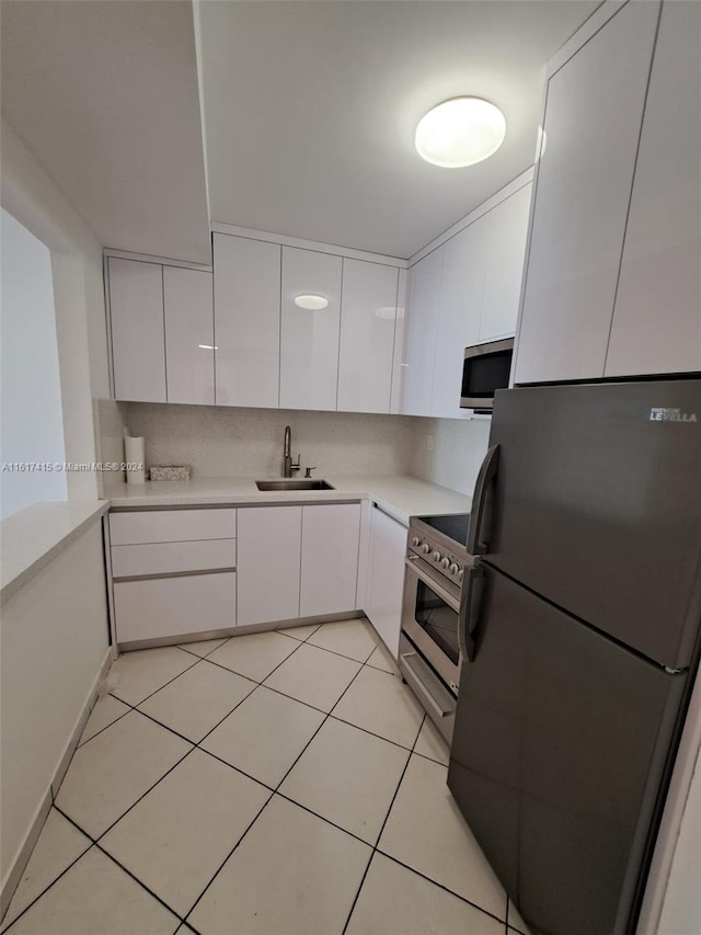 kitchen featuring sink, decorative backsplash, stainless steel appliances, and white cabinets