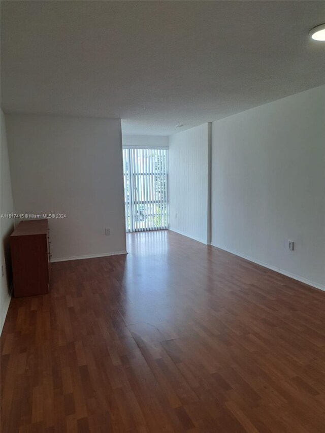 spare room with dark wood-type flooring