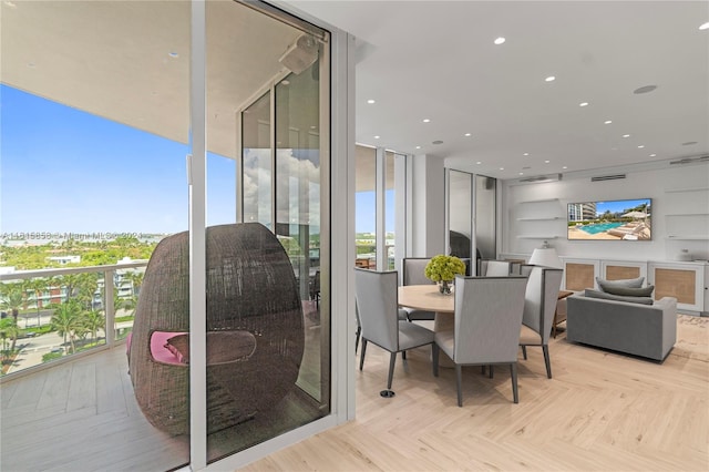 dining area featuring floor to ceiling windows, light parquet flooring, and a wealth of natural light