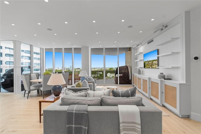 living room featuring a wall of windows and light hardwood / wood-style floors