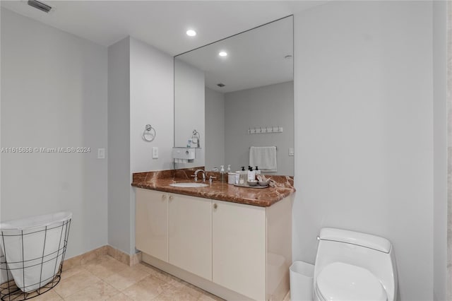 bathroom with tile patterned flooring, vanity, and toilet