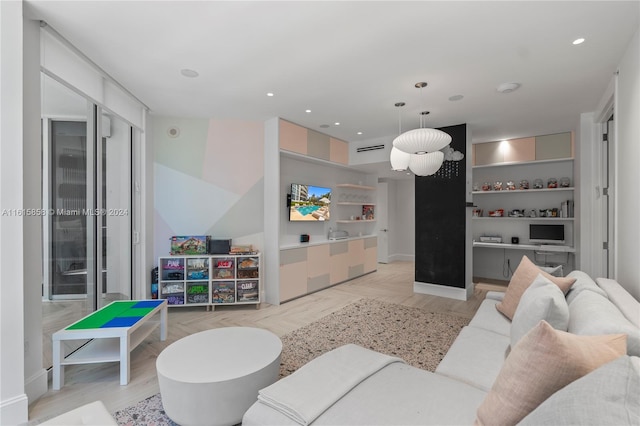 living room featuring built in shelves and light hardwood / wood-style flooring