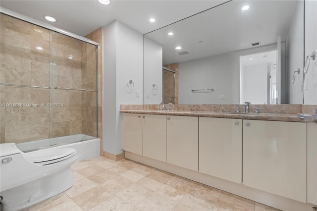 full bathroom featuring shower / bath combination with glass door, vanity, toilet, and tile patterned floors