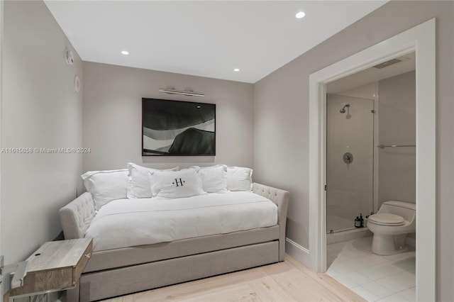 bedroom with light hardwood / wood-style flooring and connected bathroom