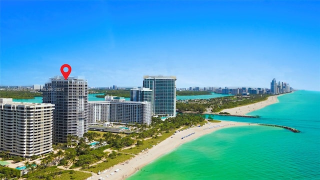 bird's eye view featuring a water view and a beach view