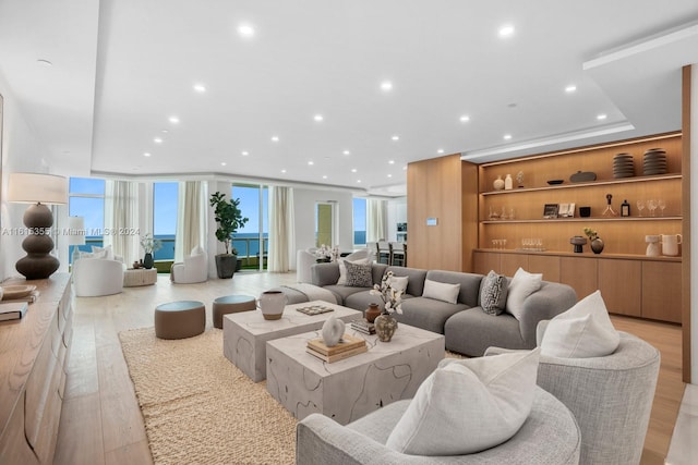 living room featuring plenty of natural light, floor to ceiling windows, and light hardwood / wood-style floors