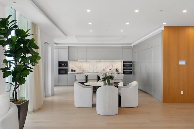 interior space with light hardwood / wood-style flooring and a raised ceiling