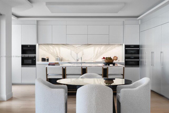 dining room with sink and light wood-type flooring