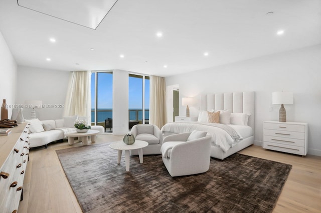 bedroom with a water view and light wood-type flooring