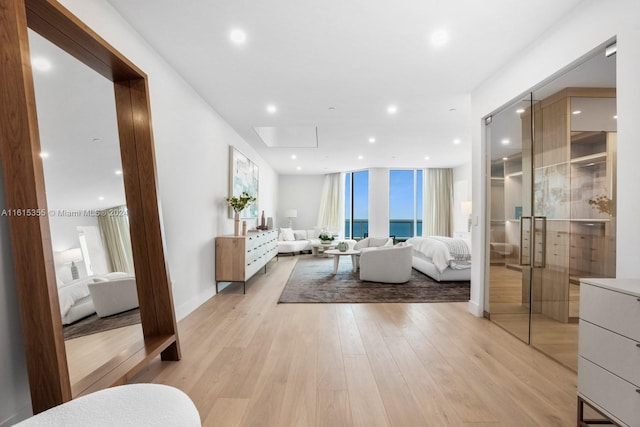 living room featuring a water view and light hardwood / wood-style floors