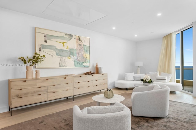 living room with a water view, hardwood / wood-style flooring, and floor to ceiling windows