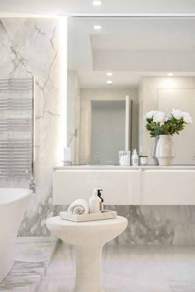 bathroom with radiator heating unit, tile patterned floors, and tile walls