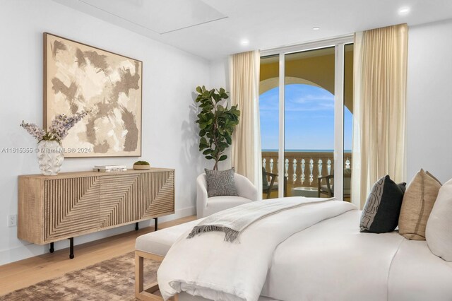 bedroom featuring access to exterior, expansive windows, and hardwood / wood-style floors