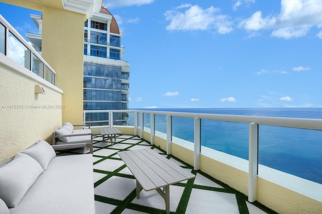 balcony with a water view and an outdoor living space