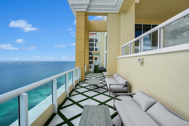 balcony with a water view and an outdoor hangout area