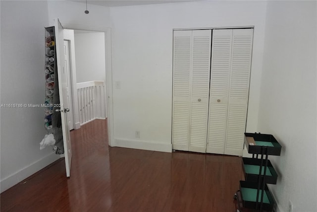 unfurnished bedroom with dark hardwood / wood-style floors and a closet