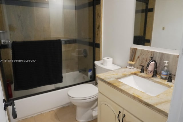 full bathroom with vanity, combined bath / shower with glass door, tile patterned flooring, decorative backsplash, and toilet