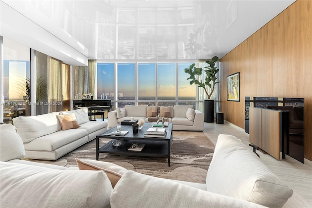 living room featuring wooden walls and floor to ceiling windows